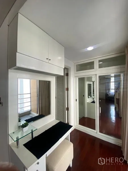 公寓 出租在Pathum Wan, Bangkok - 梳妆台角落，储物柜与通往阳台的玻璃门。