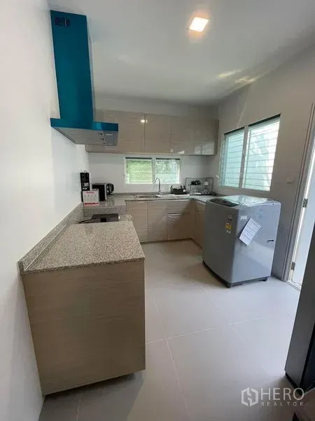 Detached House for rent in Prawet, Bangkok - Separate Thai kitchen with L‑shaped counters, range hood, windows and appliances.