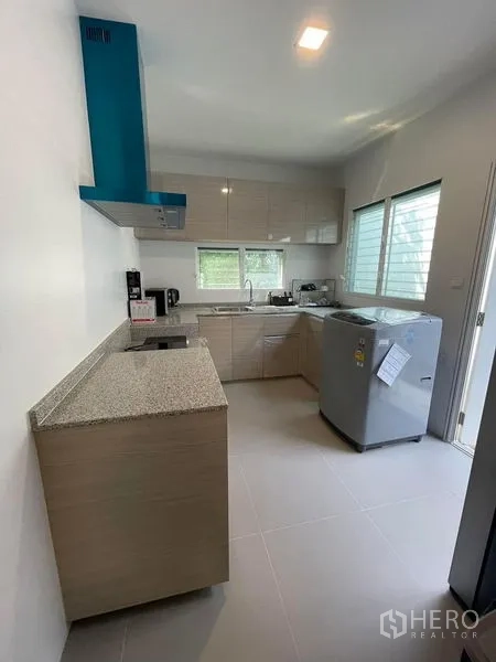 Detached House for rent in Prawet, Bangkok - Separate Thai kitchen with L‑shaped counters, range hood, windows and appliances.