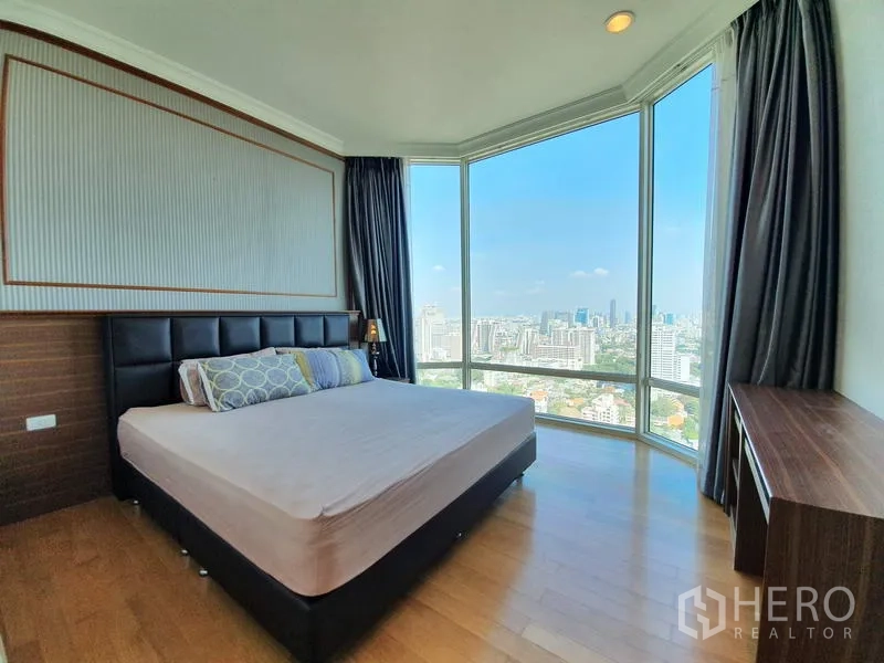 公寓 出租在Watthana, Bangkok - 主卧配特大床与转角落地窗，享受城市天际线。