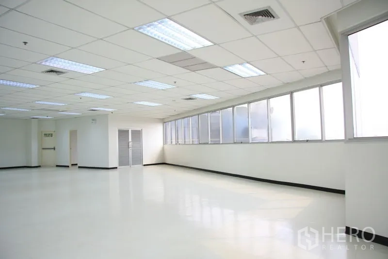 办公空间 出租在Chatuchak, Bangkok - 转角办公室，长窗采光充足，旁边设有紧急出口。