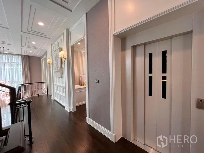 Detached House for sale in Yan Nawa, Bangkok - Upper-floor hallway featuring a private home elevator and decorative wall panels.