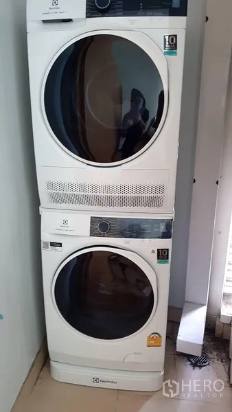 Condominium for rent in Khlong Toei, Bangkok - Stacked washer and dryer unit in the condo’s utility area.