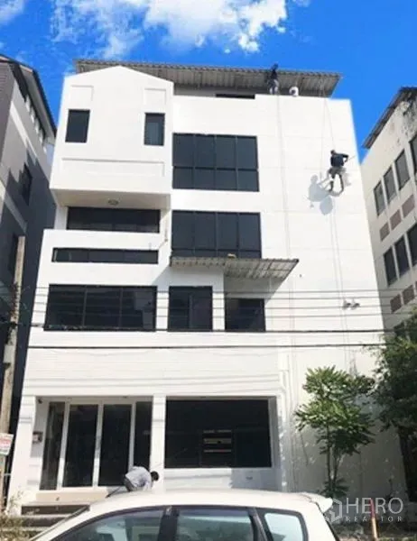 办公空间 出租或出售在Don Mueang, Bangkok - 白色多层办公楼外立面，黑框窗户与蓝天街景。