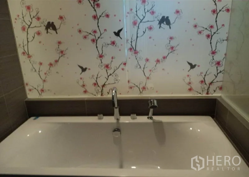 Condominium for rent in Khlong Toei, Bangkok - Modern bathroom with deep soaking bathtub and floral bird patterned glass screen.