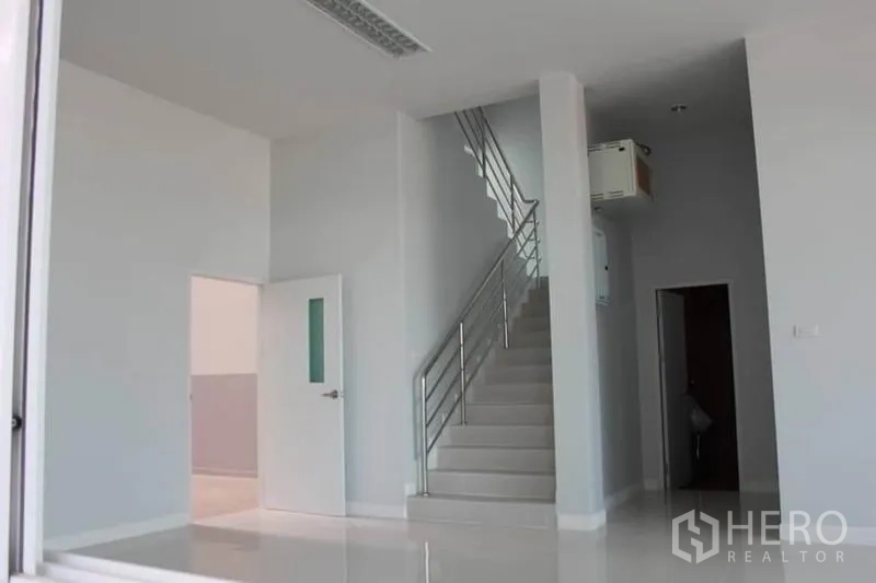 工厂 出租或出售在Lam Luk Ka, Pathum Thani - 明亮的一层办公室大堂，白色地砖与不锈钢扶梯