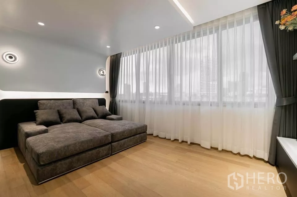 Townhouse for sale in Chatuchak, Bangkok - Cozy lounge or media room with oversized sofa and full-height windows.