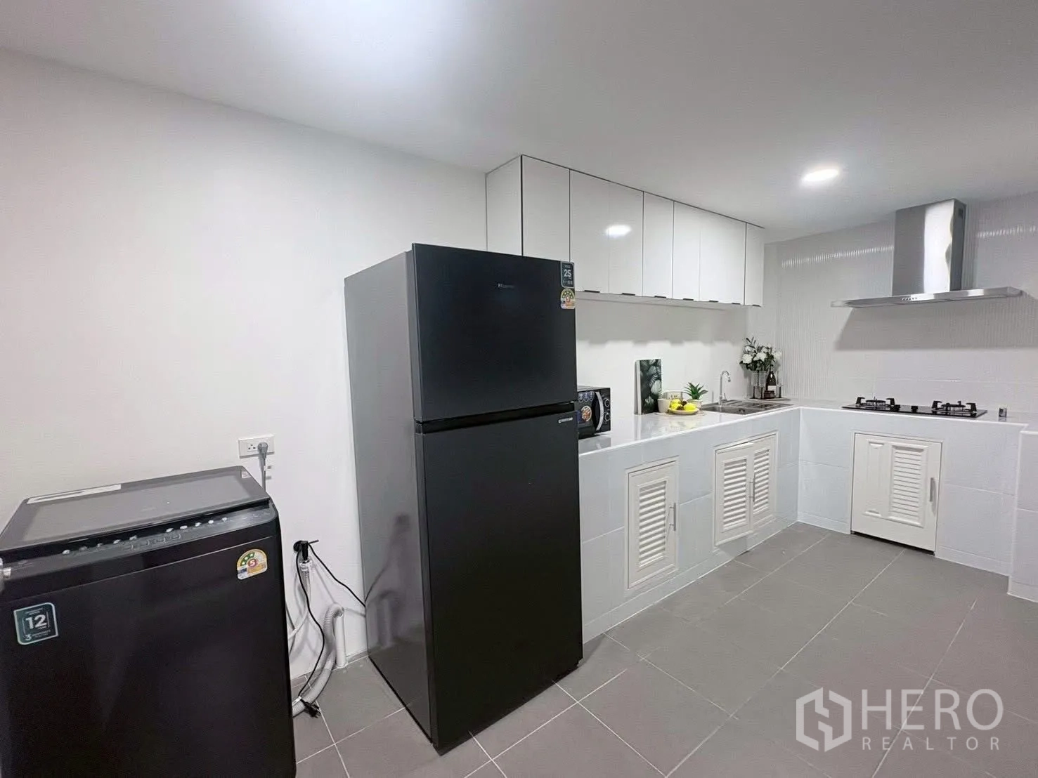 ทาวน์เฮาส์ for rent in Huai Khwang, Bangkok - มุมครัวพร้อมตู้เย็นและเครื่องซักผ้าถัดจากเคาน์เตอร์บิวท์อิน