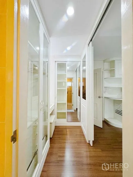 Townhouse for rent in Phra Khanong, Bangkok - Hallway with full-height storage, mirrors and wood flooring.