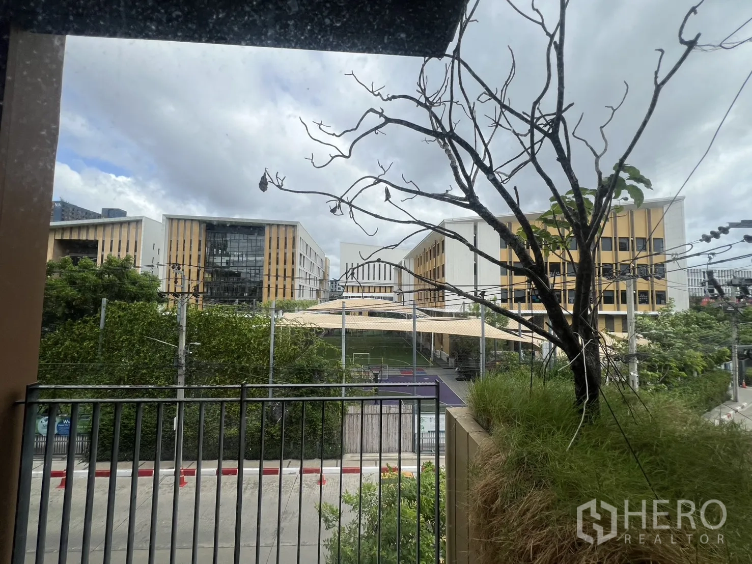 คอนโด for rent in Watthana, Bangkok - ระเบียงมองเห็นต้นไม้และอาคารสมัยใหม่ด้านหน้า
