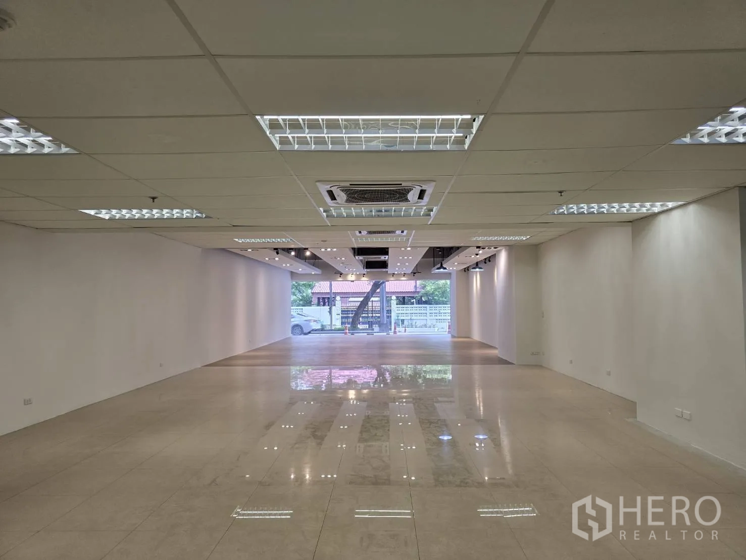 พื้นที่ขายของ for rent in Watthana, Bangkok - พื้นที่โชว์รูมแปลนโล่ง พื้นเงา ผนังสีขาว และไฟเพดานสว่าง