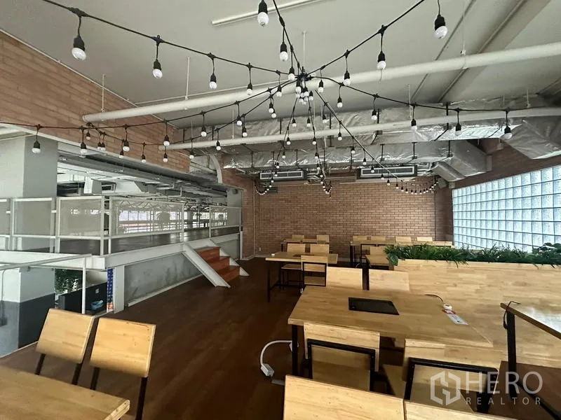 Retail Space for rent in Watthana, Bangkok - Mezzanine dining view with glass-block wall and pendant string lights.