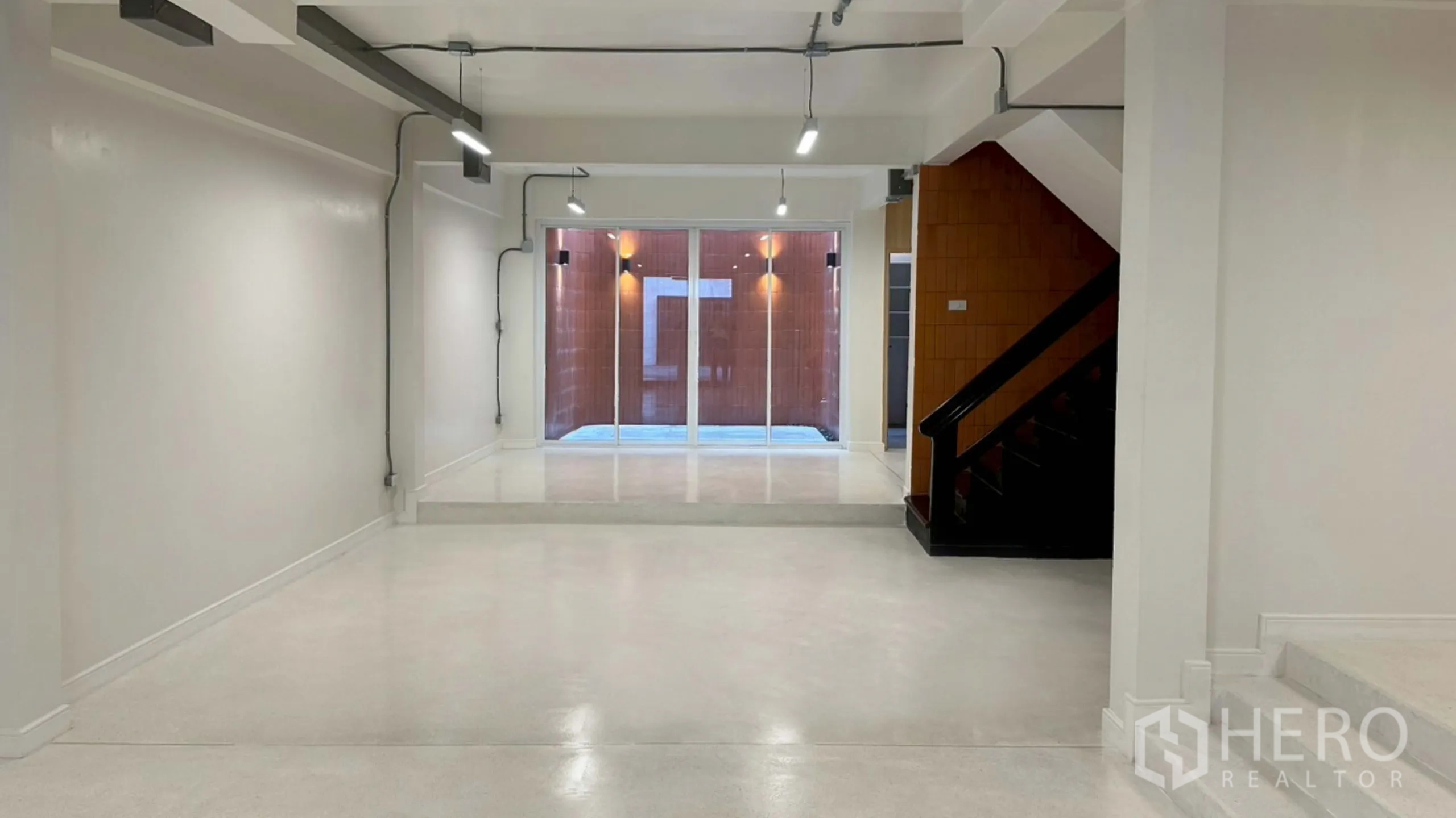 Home Office for rent in Watthana, Bangkok - Open white studio area leading to a lighted patio through sliding doors.
