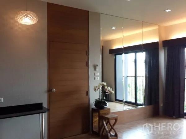 คอนโด ให้เช่าในWatthana, Bangkok - โถงทางเข้าพร้อมโคมไฟแขวน ผนังกระจก และประตูกระจกสไลด์ออกสู่ระเบียง