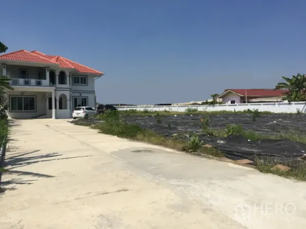 Detached House for rent in Saphan Sung, Bangkok - Two-storey detached house with red tile roof, long driveway, and expansive fenced land.