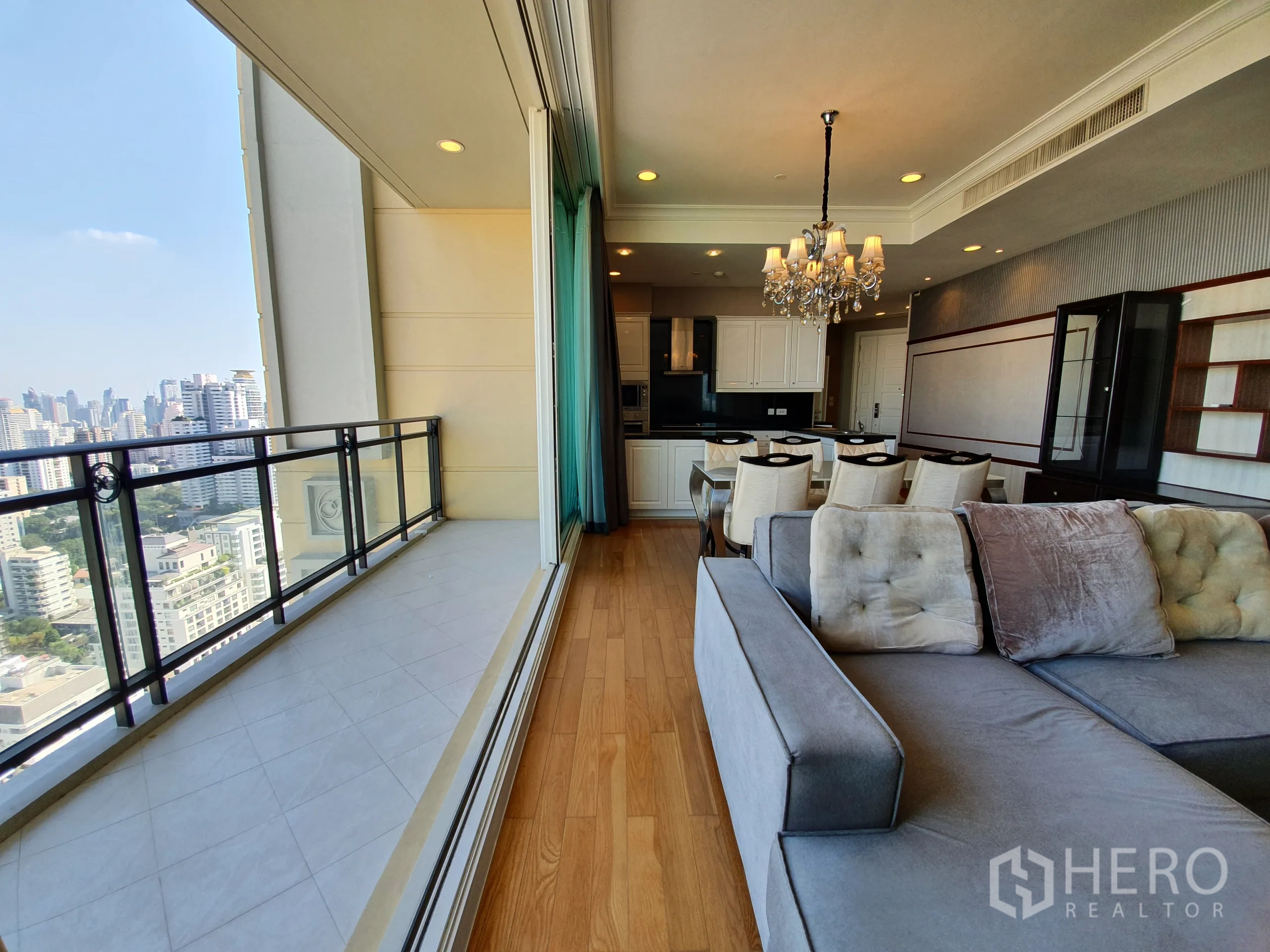 公寓 出租在Watthana, Bangkok - 狭长阳台带栏杆俯瞰曼谷，推拉门与开放式客餐厨相连。
