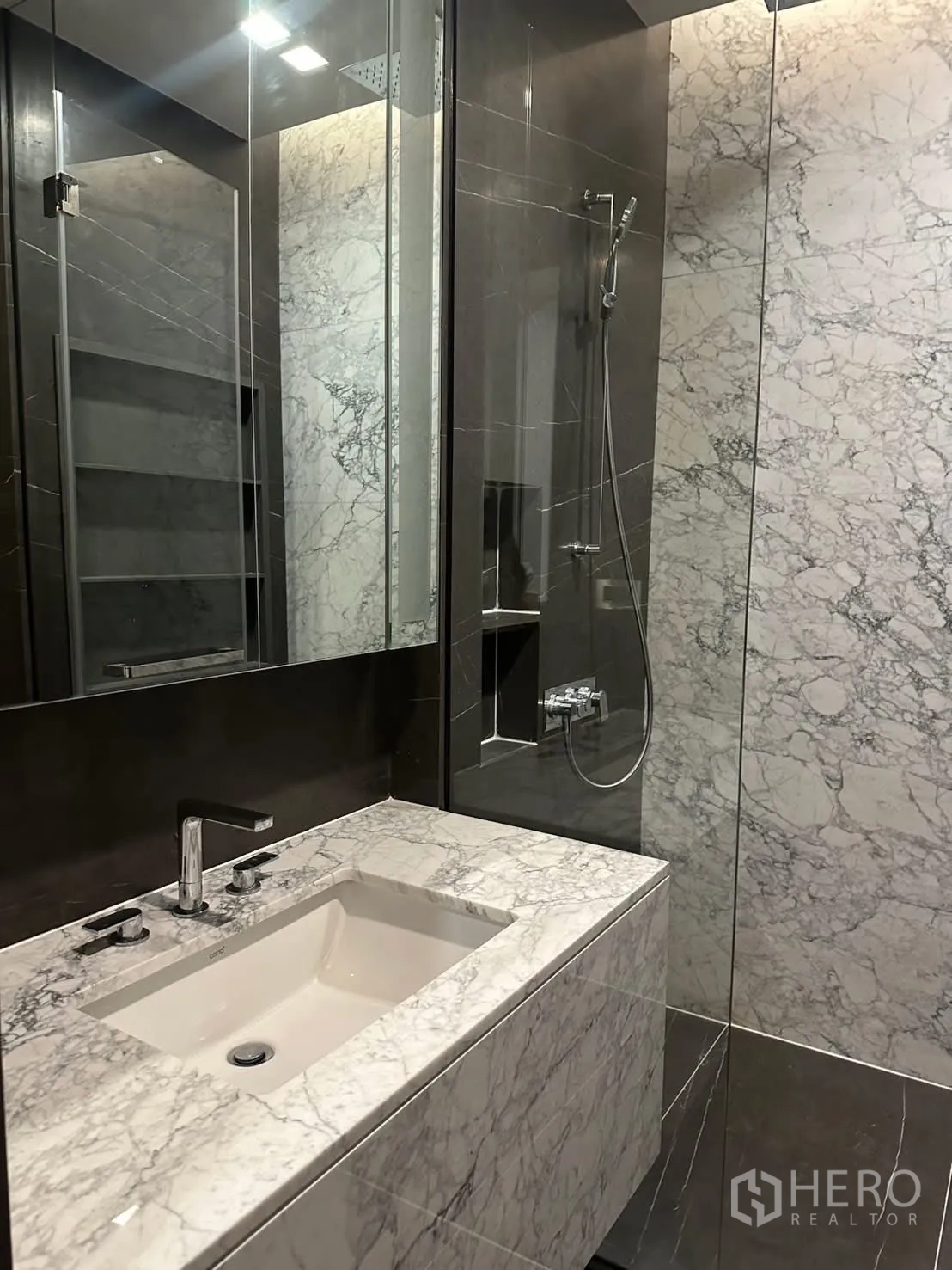 คอนโด for rent or sale in Watthana, Bangkok - ห้องน้ำกรุหินอ่อนพร้อมเคาน์เตอร์อ่างล้างหน้าและตู้กระจกอาบน้ำ.