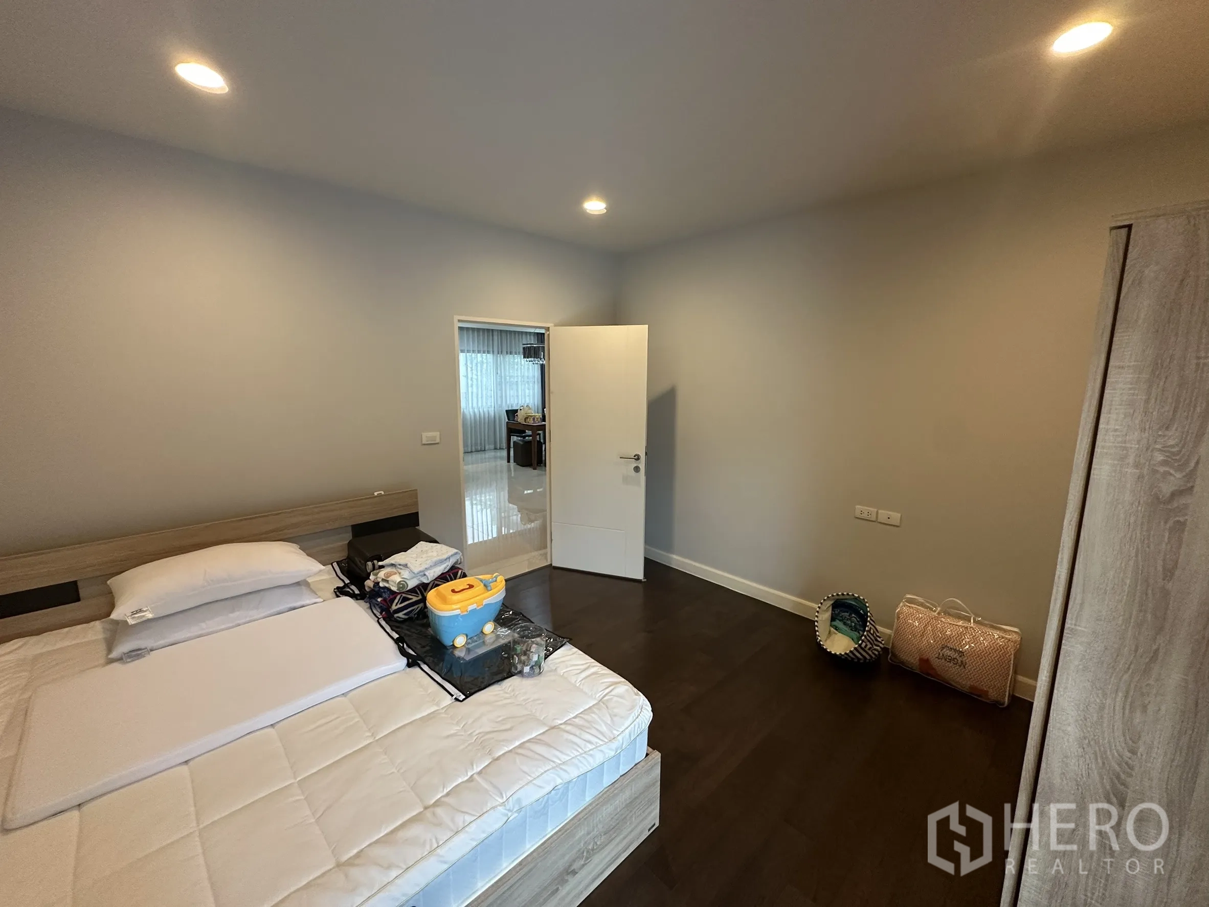 Detached House for rent in Lam Luk Ka, Pathum Thani - Guest bedroom with bed, wardrobe and door to hallway.