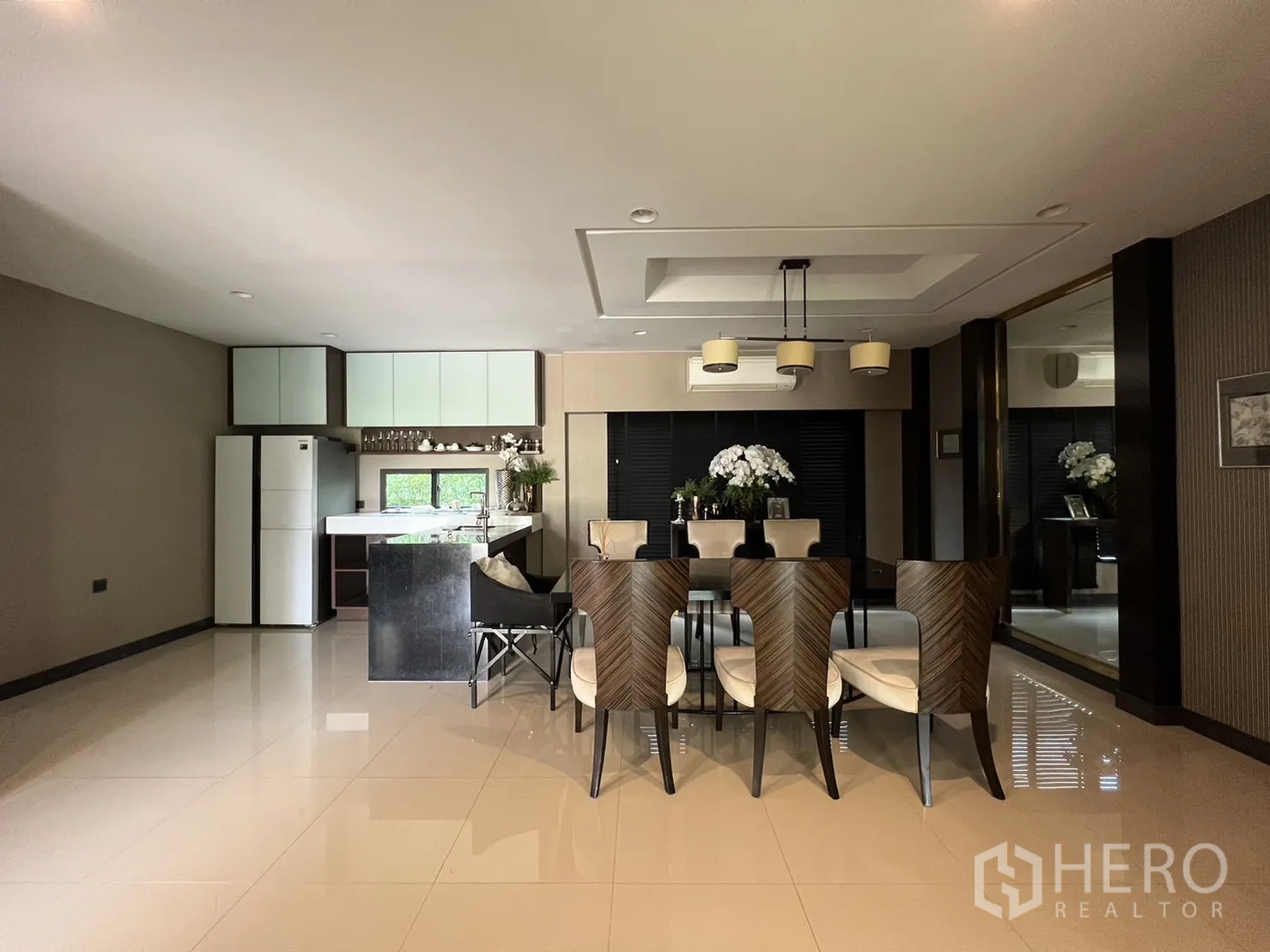 Detached House for rent or sale in Bang Kapi, Bangkok - Large dining room with patterned chairs adjoining a pantry kitchen island.