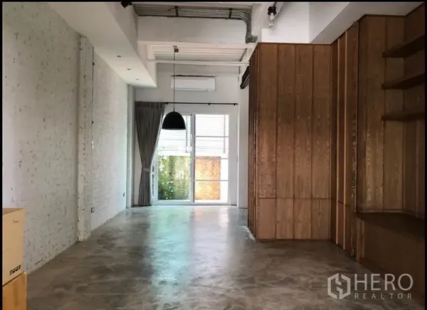 ทาวน์เฮาส์ ขายในWang Thonglang, Bangkok - พื้นที่นั่งเล่นแบบเปิด พื้นปูนขัดมัน โคมไฟแขวน และประตูกระจกบานเลื่อน