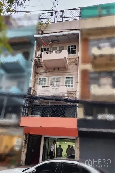 店屋 出租在Phaya Thai, Bangkok - Ari区多层店屋外立面，配橙色雨棚、阳台与玻璃门面。