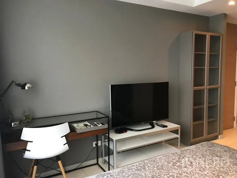 公寓 出租在Watthana, Bangkok - 一居公寓内的书桌、电视与储物柜，位于瓦他那区