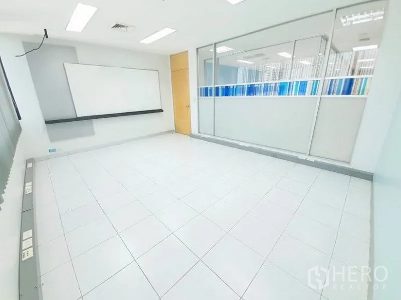 Office Space for rent in Bang Na, Bangkok - Tiled office with a whiteboard and glass partition with blue stripe privacy film.