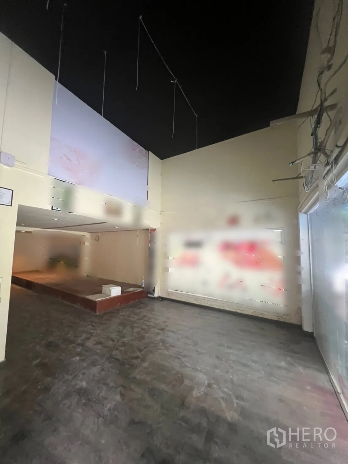 店屋 出租在Watthana, Bangkok - 前厅挑高空间，黑色高顶、悬挂电线与整面展示玻璃。