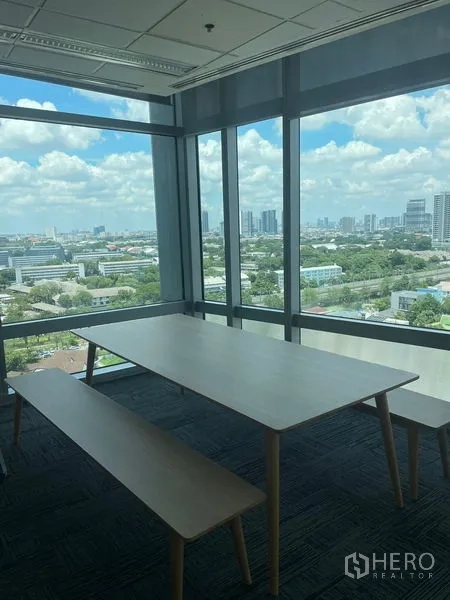 Office Space for rent in Dusit, Bangkok - Corner break area with table and bench by glass walls offering panoramic city views.