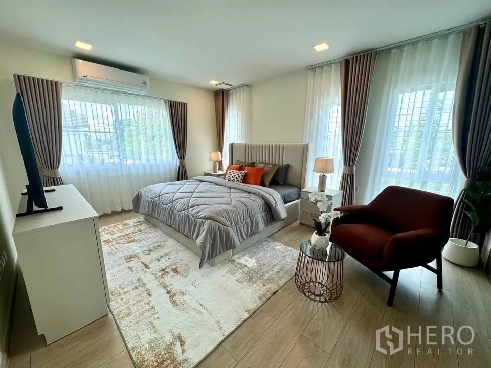 Detached House for rent in Bang Phli, Samut Prakan - Master bedroom from another angle showing lounge chair and multiple windows.