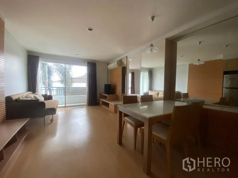 公寓 出租在Watthana, Bangkok - 开放式客餐厅，配沙发、餐桌、电视柜，落地滑门通向阳台，采光充足。