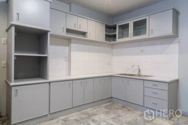Home Office for rent in Bang Rak, Bangkok - L-shaped kitchen with gray cabinetry, tiled backsplash and stainless sink.