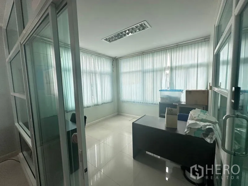 Warehouse for rent or sale in Lam Luk Ka, Pathum Thani - Glass‑partitioned corner office with desk, blinds and glossy tiled floor.