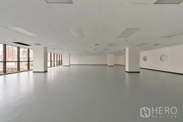 Office Space for rent in Pathum Wan, Bangkok - Expansive office interior with widely spaced columns, suspended ceiling panels and panoramic glazing.