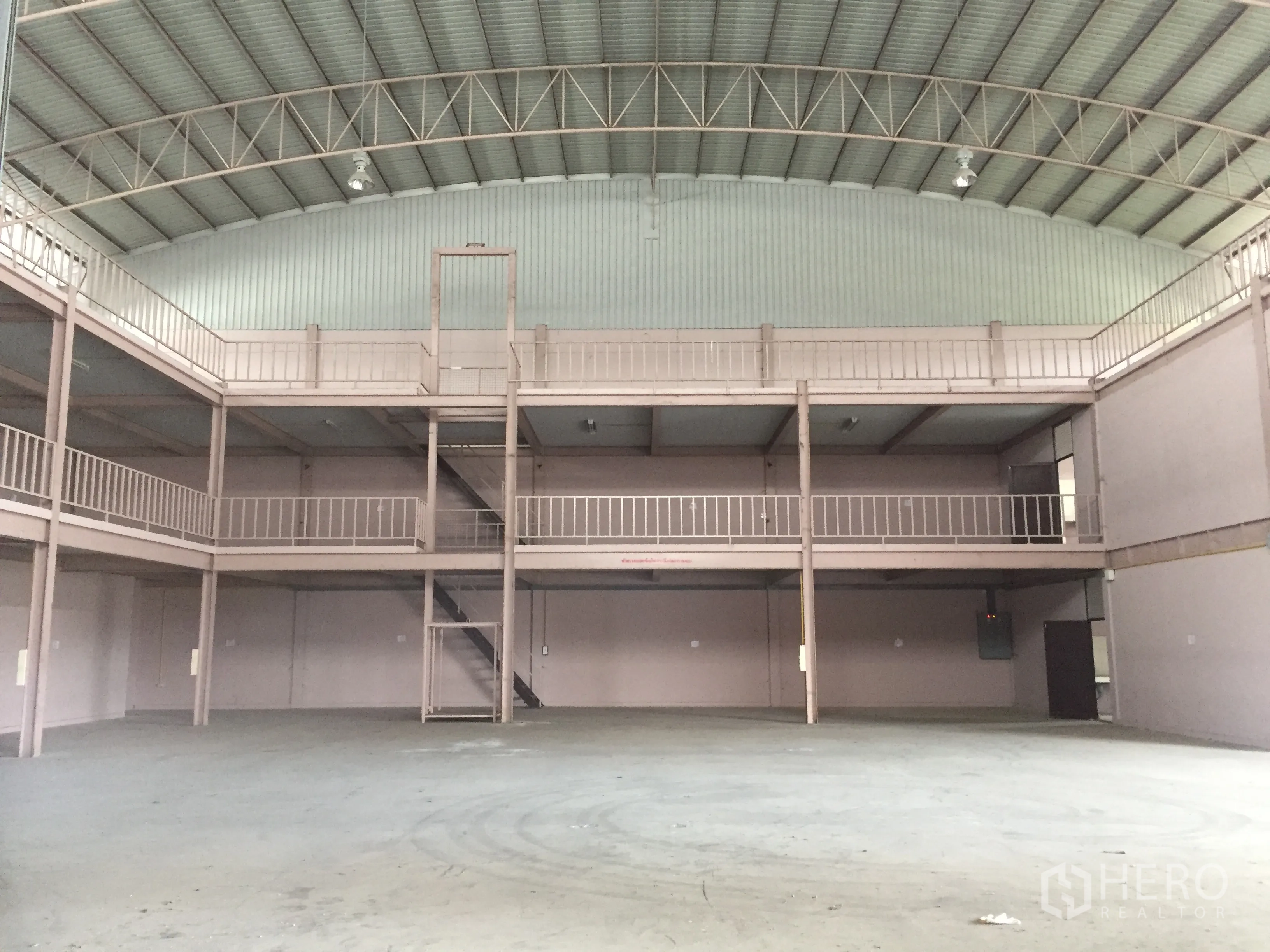 Factory for rent in Lam Luk Ka, Pathum Thani - Front view of expansive production hall with double mezzanine and central staircase.