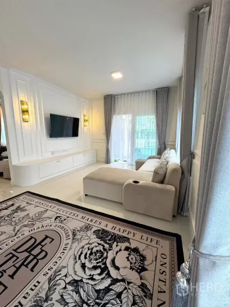 Detached House for rent in Bang Phli, Samut Prakan - TV feature wall with built-in cabinetry beside a corner sofa and tall drapes.