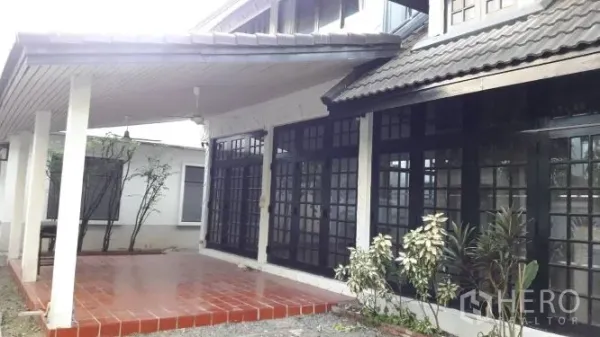 Detached House for rent in Yan Nawa, Bangkok - Terrace with roof awning and a wall of black-framed French windows along the house.