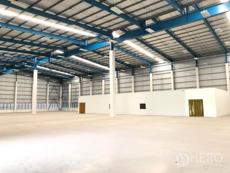 Warehouse for rent in Bang Phli, Samut Prakan - Spacious high-bay warehouse interior with steel trusses and smooth concrete floor.