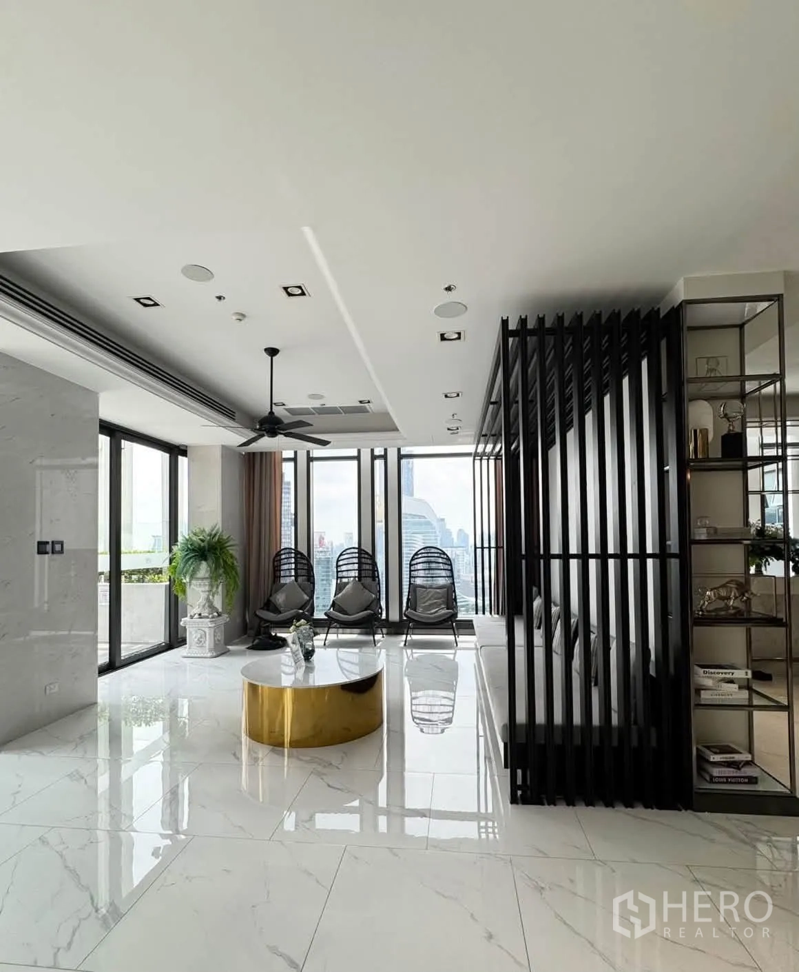 Condominium for rent in Pathum Wan, Bangkok - Modern sky lounge with hanging chairs, marble floors, and city-facing windows.