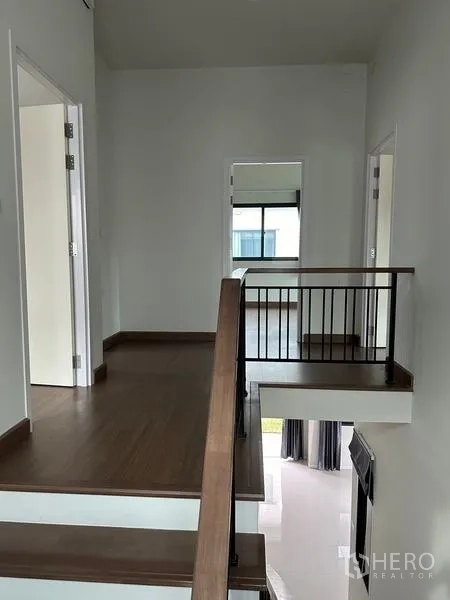 独立式住宅 出售在Khlong Sam Wa, Bangkok - 木地板的二层梯厅，栏杆连接各卧室