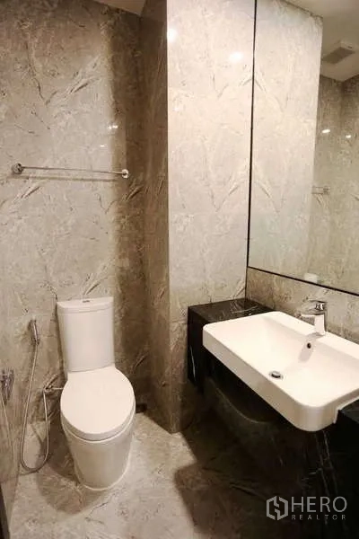 公寓 出租在Watthana, Bangkok - 现代卫浴，超大镜面、白色台盆与马桶，大理石墙面并配喷枪
