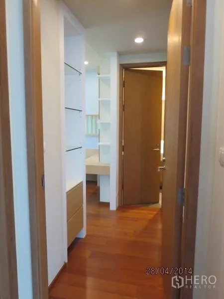 Condominium for rent in Bang Rak, Bangkok - Hallway with built-in shelves and cabinetry leading toward the bedrooms.