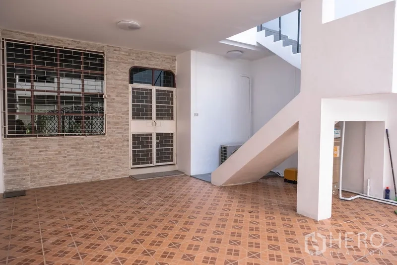 Home Office for rent in Khlong Toei, Bangkok - Covered carport with patterned tile floor and secure doors, suitable for parking.