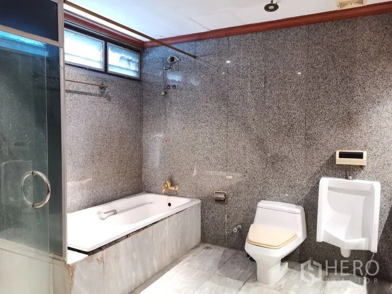 公寓 出售在Watthana, Bangkok - 花岗岩卫生间，设浴缸、玻璃淋浴间、坐便器与小便器。