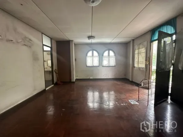Detached House for sale in Phra Khanong, Bangkok - Large living space with parquet floor, twin arched windows and access to a balcony.
