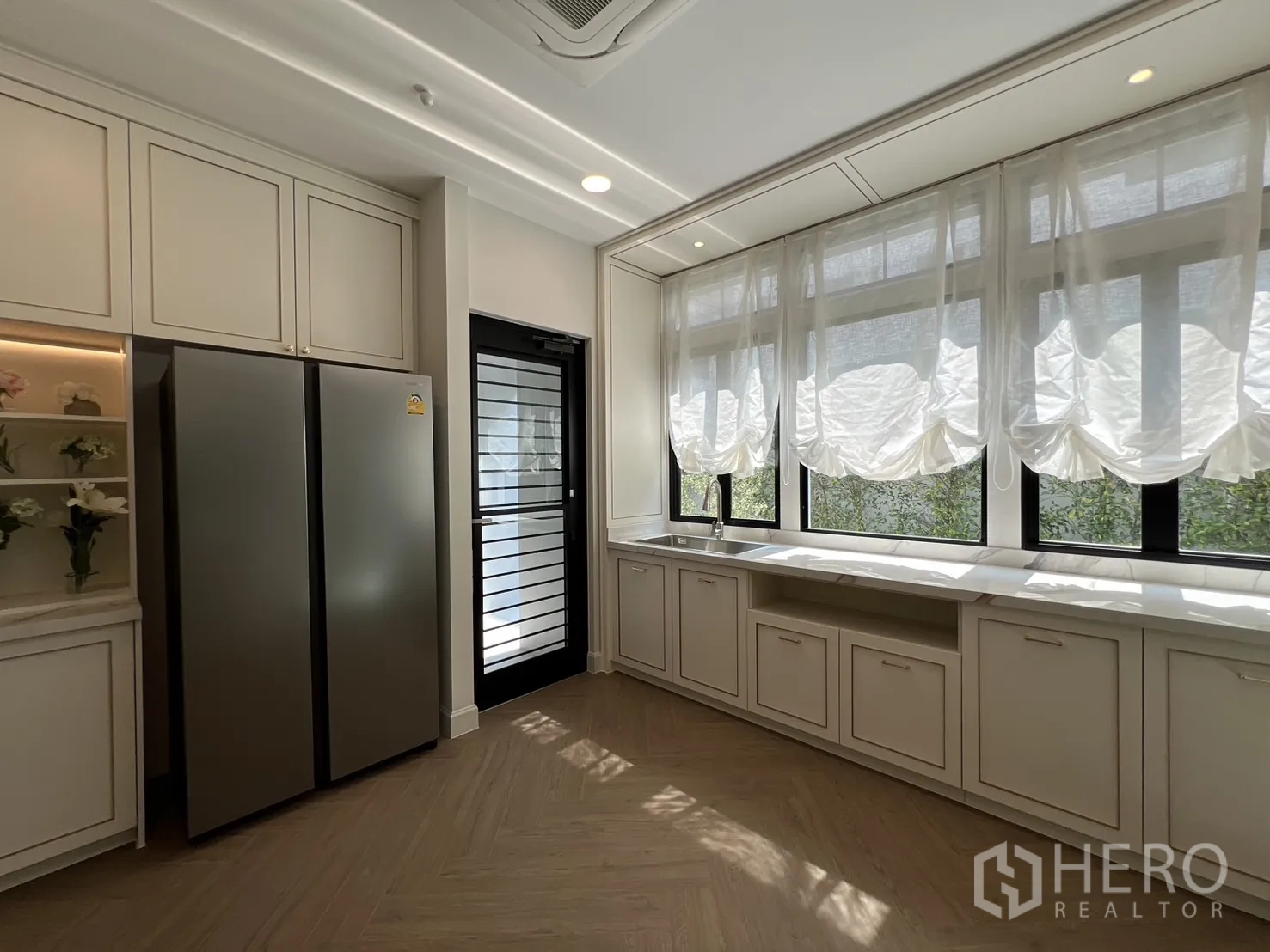 Detached House for rent in Saphan Sung, Bangkok - Kitchen with full-height windows, long sink counter and storage.