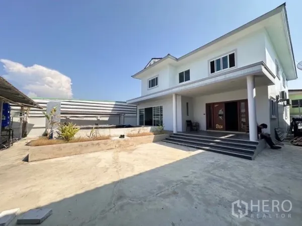 货栈 出售在Bang Phli, Samut Prakan - 园区内的两层私人住宅，带台阶门廊与宽阔硬化庭院停车区。