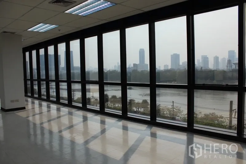 办公空间 出租在Watthana, Bangkok - 采光充足的开放式办公室一角，落地窗可观湖景与城市天际线。