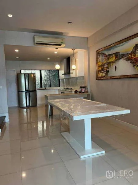 联排别墅 出租在Khlong Toei, Bangkok - 餐区面向厨房，设大理石餐桌、不锈钢冰箱与顶灯