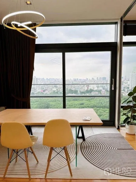 คอนโด ให้เช่าในRatchathewi, Bangkok - มุมทานอาหารเก้าอี้สองตัว บนพรมลายกราฟิก ข้างประตูกระจกบานเลื่อนพร้อมวิวสกายไลน์